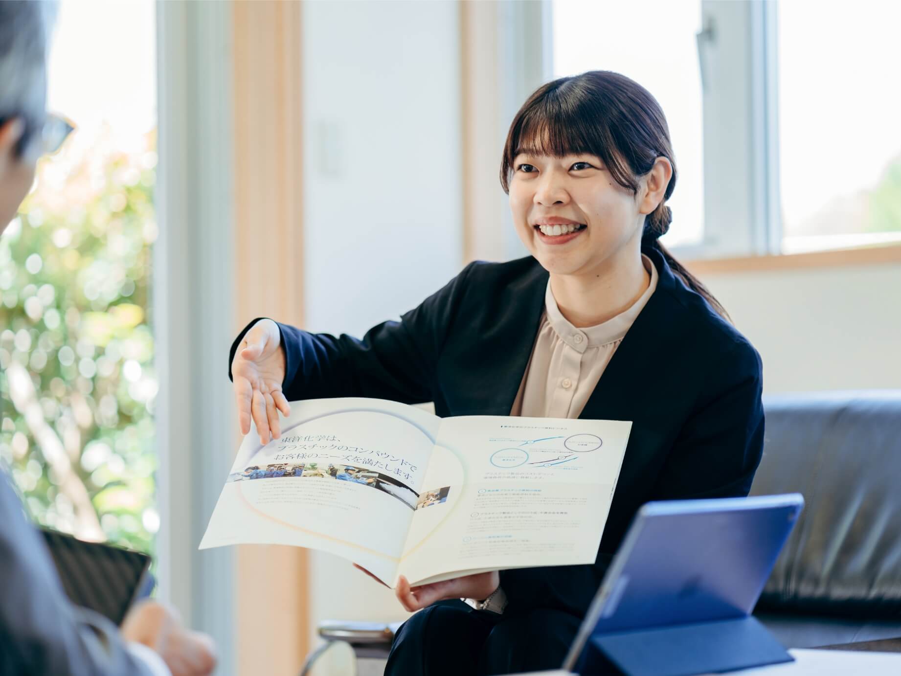 資料を用いて説明をする女性